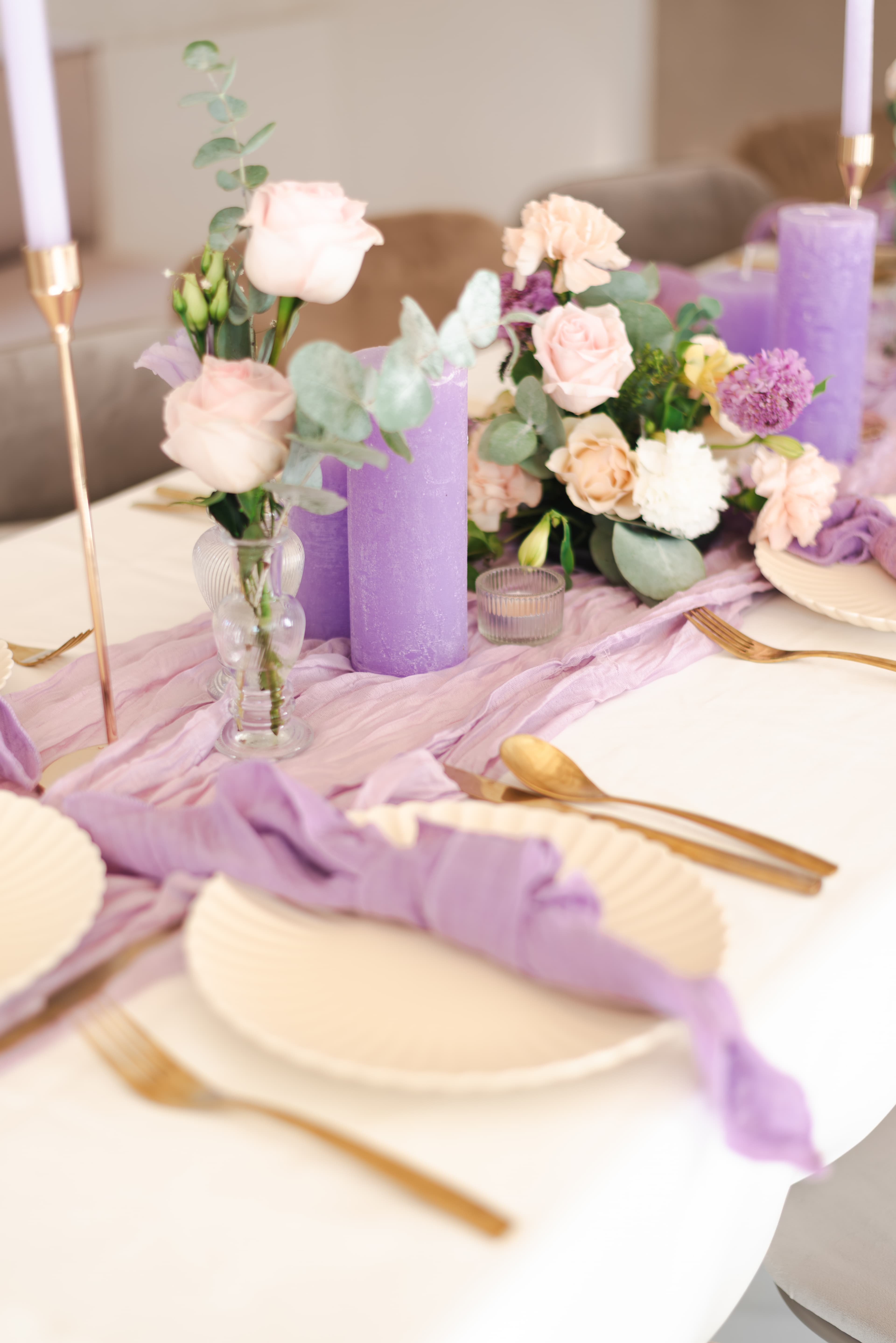Paarse tafelstyling met bloemen en kaarsen